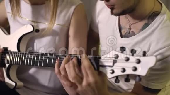 女孩一边弹吉他一边看着男人视频的预览图