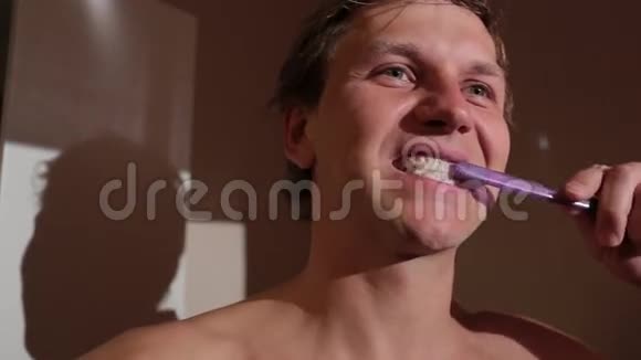 年轻人刷牙他赤裸着上身站在浴室里视频的预览图