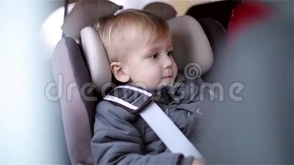小男孩坐在汽车座椅上饶有兴致地环顾四周视频的预览图