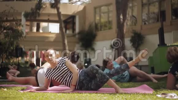 在户外草地上练习瑜伽的妇女团体视频的预览图