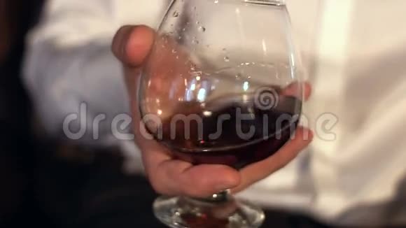 人在玻璃中慢慢搅拌干邑慢动作男人手里拿着一杯威士忌视频的预览图