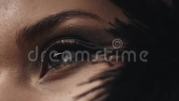 女性面部特写模特护肤化妆品装饰化妆品轻轻触摸脸颊上的黑色羽毛眼睛马斯卡视频的预览图