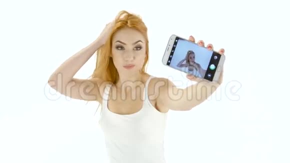红发模特女孩在你的智能手机上自拍怀特工作室视频的预览图