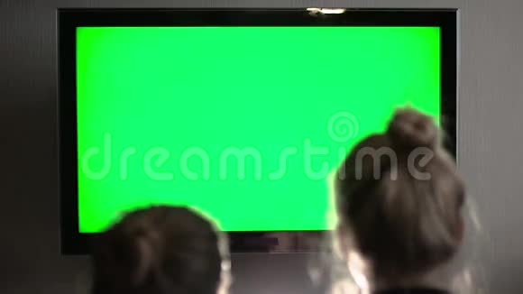 两个长头发的金发女郎看着绿色的电视屏幕笑着视频的预览图