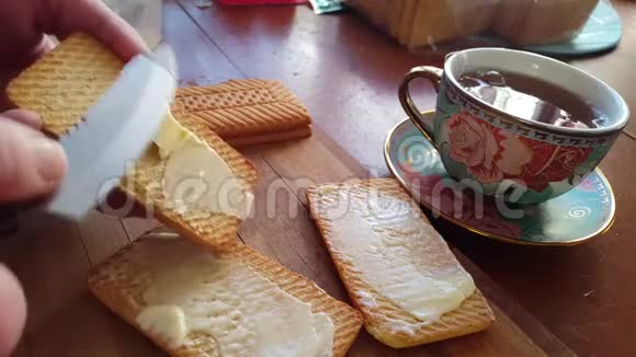 用刀子把黄油撒在麦饼干上吃早餐视频的预览图