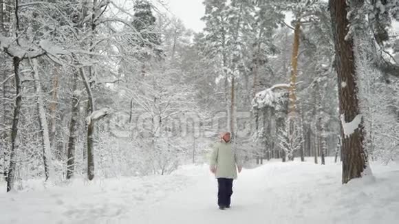 在树林里散步的养老金领取者这位女士喜欢走步道的长假白雪覆盖的就是我们视频的预览图