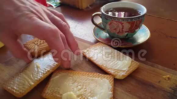 用刀子把黄油撒在麦饼干上吃早餐视频的预览图