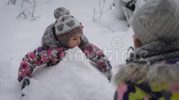 妈妈和女儿在树林里那个女孩高兴地花时间冲雪球冬天休息布林视频的预览图