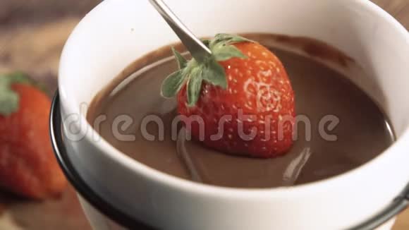 在巧克力中蘸上美味的红色草莓视频的预览图