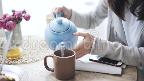 一个女人在咖啡馆里给她的朋友倒茶视频的预览图