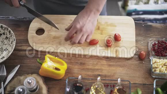 一位厨师在切樱桃西红柿并将其放入碗中的俯视图视频的预览图