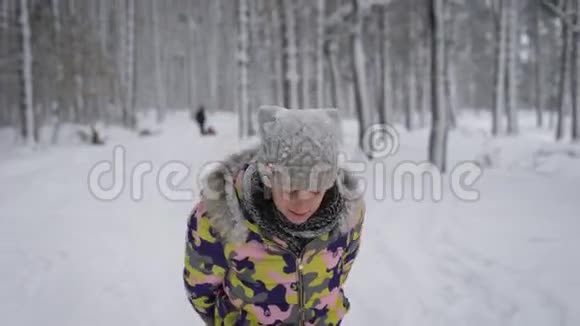 在树林里的年轻家庭母亲带着女儿花空闲时间骑雪橇那个女孩骑在船上视频的预览图