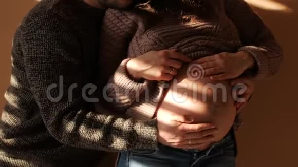 爸爸把手放在怀孕的肚子上怀孕夫妇抚摸怀孕的肚子准妈妈照顾视频的预览图