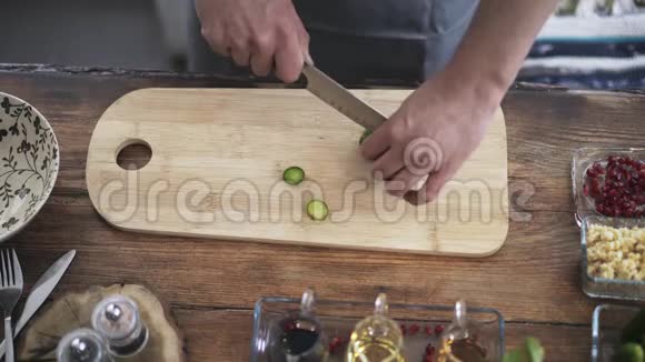 一位厨师在咖啡馆的木板上切黄瓜的俯视图视频的预览图