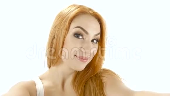 红头发的女孩在相机上摆姿势拍照特写镜头白色背景视频的预览图