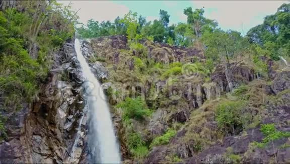 蓝天绿树间瀑布的鸟瞰图视频的预览图