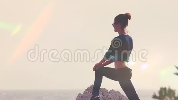日落海滩上的年轻女子剪影瑜伽视频的预览图