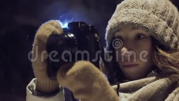 女孩摄影师拍摄户外雪冬夜利公园视频的预览图