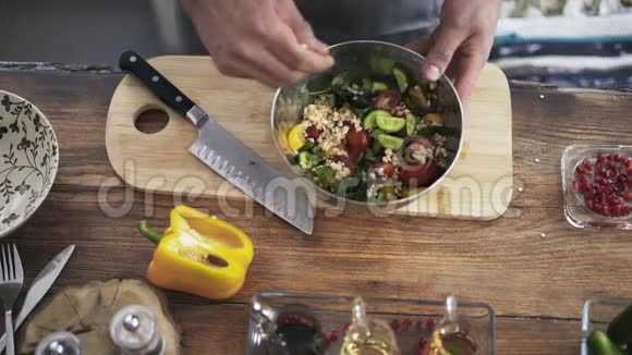 一位厨师将蔬菜沙拉配料混合在金属碗中的俯视图视频的预览图