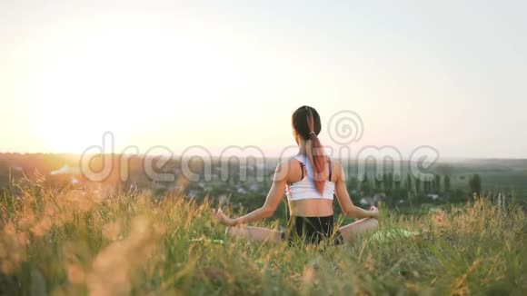 在日落时分在野外做瑜伽的瘦女孩视频的预览图