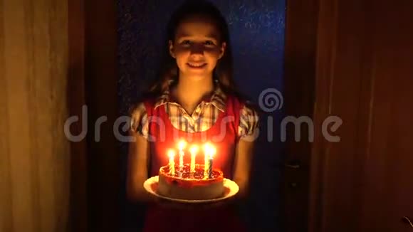 女孩拿着生日蛋糕和黑暗中的蜡烛视频的预览图