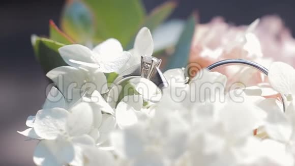 婚礼戒指在一束白色的花上快关门婚礼戒指和白色和白色花束的旋转组合视频的预览图