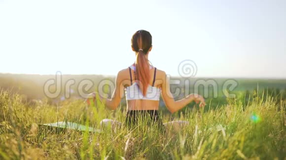 在日落时在野外做瑜伽的瘦女孩视频的预览图
