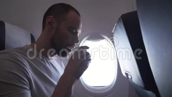 一个人坐在飞机的窗户附近喝着纸杯里的饮料视频的预览图