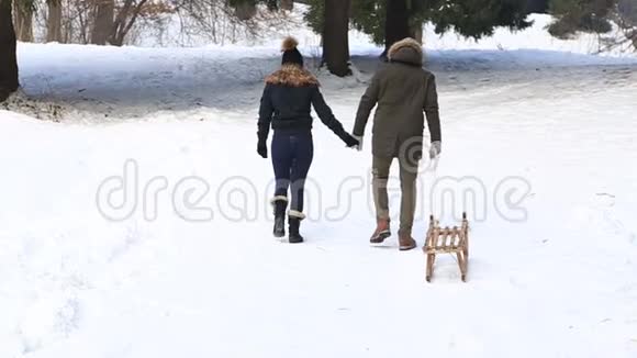 漂亮的一对夫妇花时间在公园里他们滑滑梯玩得很开心下雪天气视频的预览图