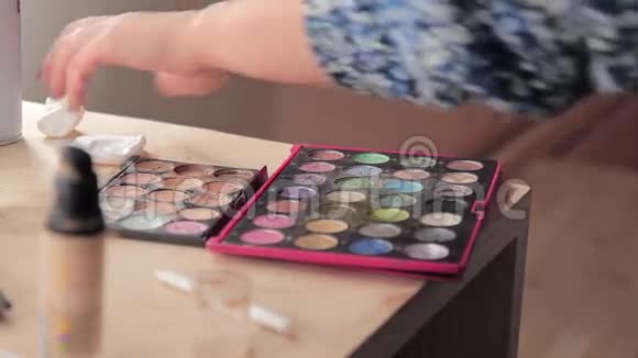 化妆师用画笔和眼影调色板她的手视频的预览图