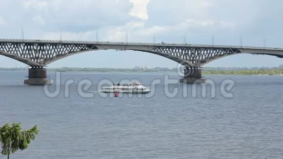 在河上的游船在萨拉托夫和恩格斯两个城市之间的伏尔加河上的桥梁俄罗斯视频的预览图