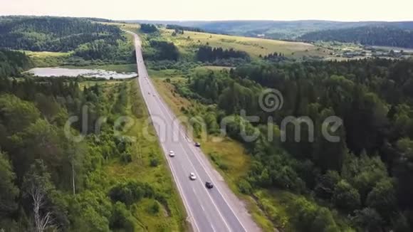 鸟瞰夏季绿树河流道路的森林背景道路弯曲路径的鸟瞰图视频的预览图