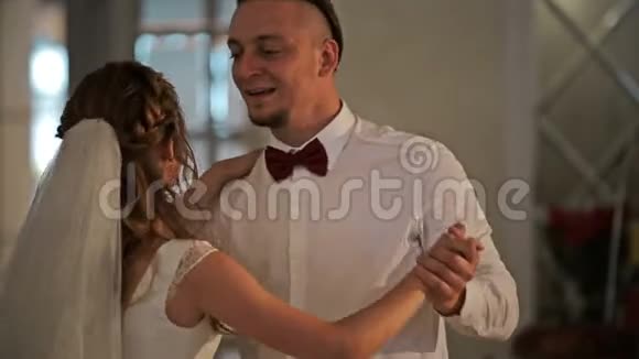 一对年轻漂亮的新婚夫妇在餐厅里的第一次婚礼舞蹈闭合视频的预览图