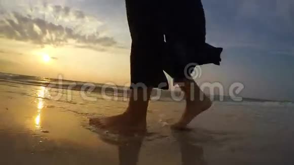 4K一个女人在日落时沿着海滩散步的实时镜头视频的预览图