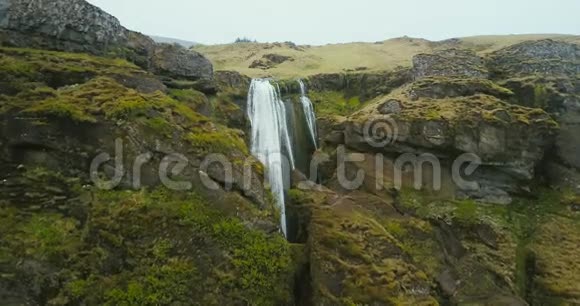 冰岛山上瀑布的鸟瞰图直升机在湍流附近飞落下来视频的预览图