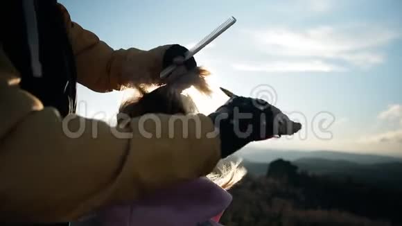 在悬崖上剪了个极好的发型年轻的男理发师在户外为一个女人理发一家美发店在上面视频的预览图