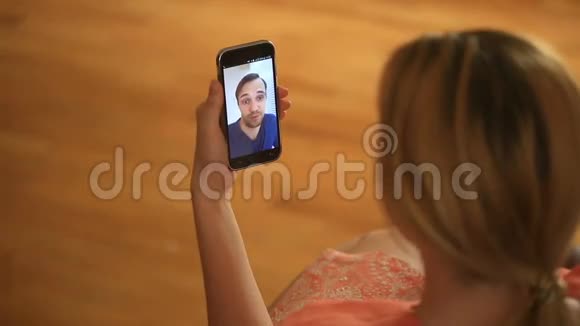 一个女人在智能手机上和一个男人举行视频聊天他们谈笑风生视频的预览图