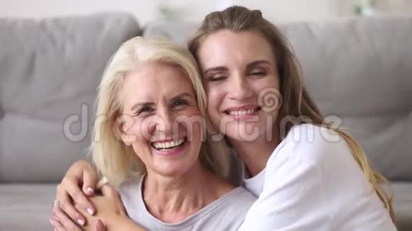快乐的老母亲拥抱着年轻的成年女人笑视频的预览图
