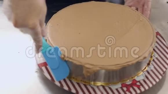 一个糖果师把奶油撒在蛋糕上站在蛋糕架上视频的预览图