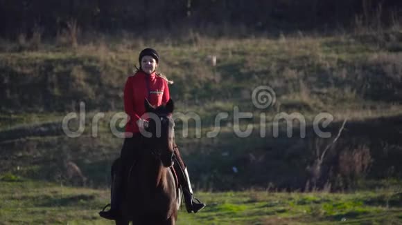 骑马在绿野上疾驰的马女慢动作视频的预览图