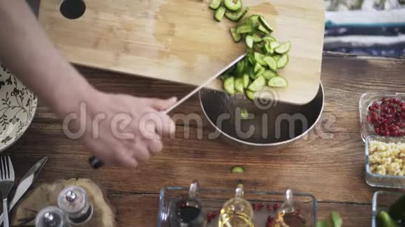 厨师将切好的黄瓜放入金属碗中的俯视图视频的预览图
