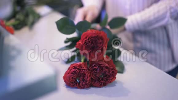 在一家花店做玫瑰花束的女人的贴身工作视频的预览图