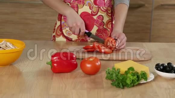 可爱的女孩在厨房切西红柿视频的预览图