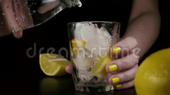 女人的手从瓶子里把水倒进玻璃杯里慢节奏视频的预览图