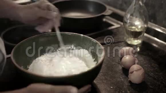 一个厨师在碗里把鸡蛋和面粉混合做成面团的实时录像视频的预览图