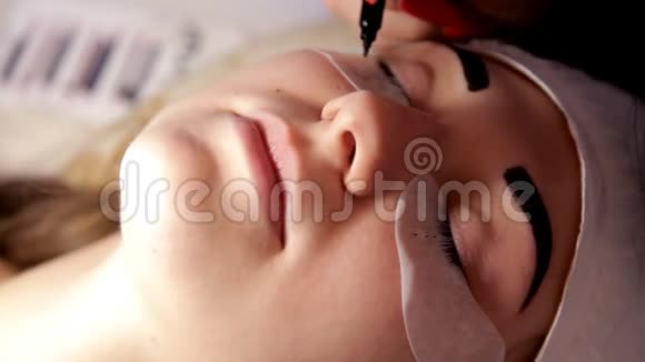 在美容院化妆师为女孩准备睫毛延伸的程序特写视频的预览图