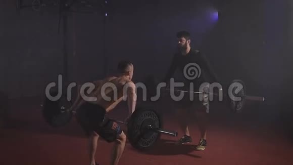 两个强壮的男人在健身房同时用杠铃做举重视频的预览图