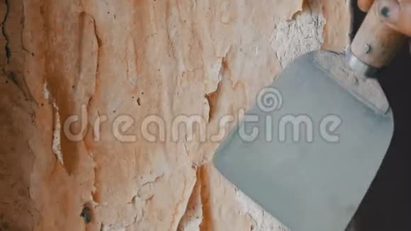 人用专用抹刀剥旧壁纸墙上有黄色破旧的墙纸家修关门视频的预览图