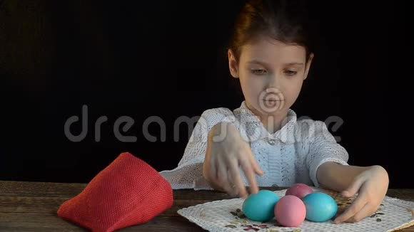 小女孩把彩色鸡蛋放进袋子里视频的预览图