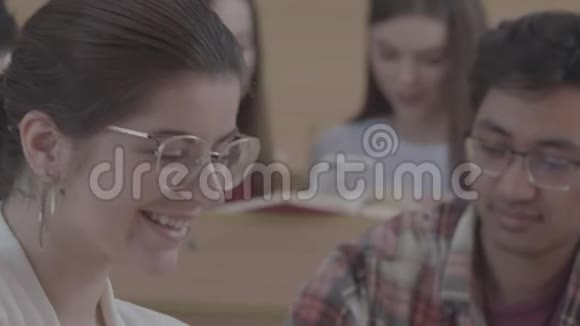 微笑笑的女孩坐在大学里视频的预览图